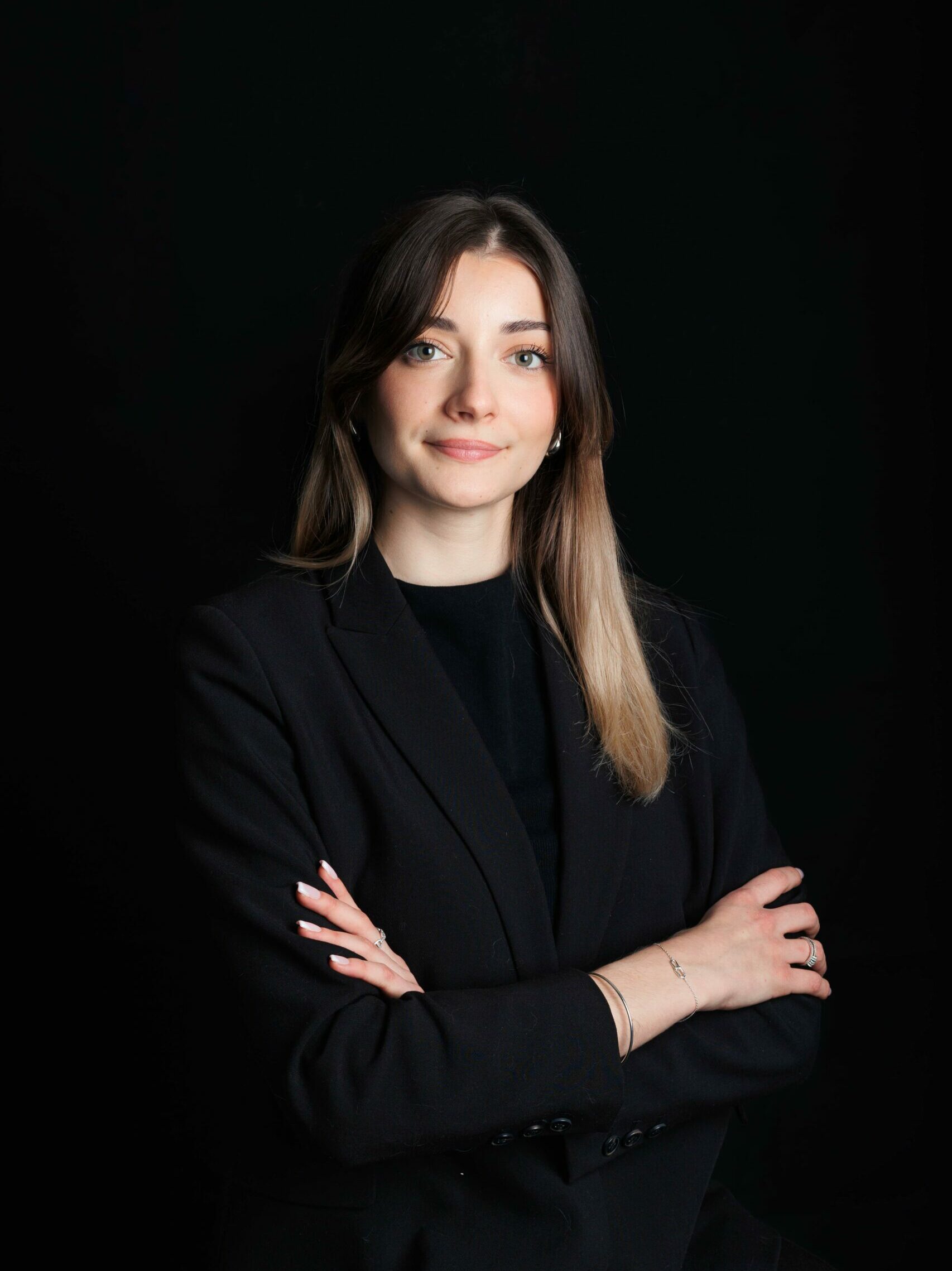 Photographie de portrait corporate de Céline Marti, photo studio sur fond noir.